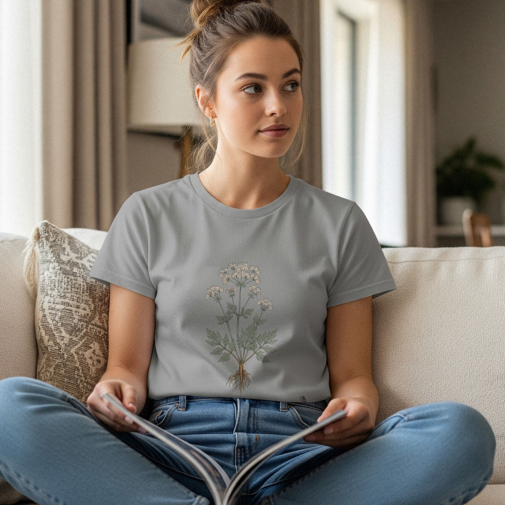 Woman reading on a sofa wearing a botanical tee